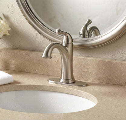 Bathroom sink with silver faucet and round mirror above