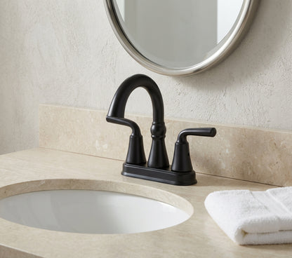 Black faucet on a bathroom vanity with a mirror above